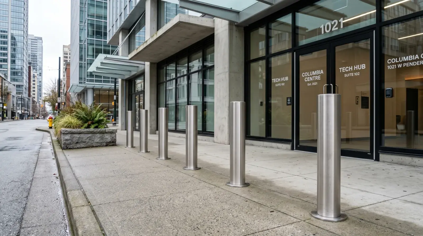 Row of stainless steel security bollards in front of a Vancouver commercial storefront entrance