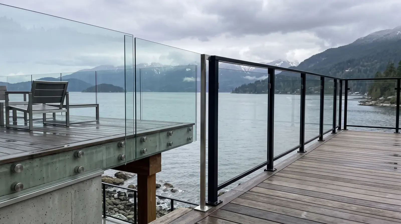 Frameless standoff glass railing and framed post-supported glass railing side by side on a West Vancouver oceanfront deck