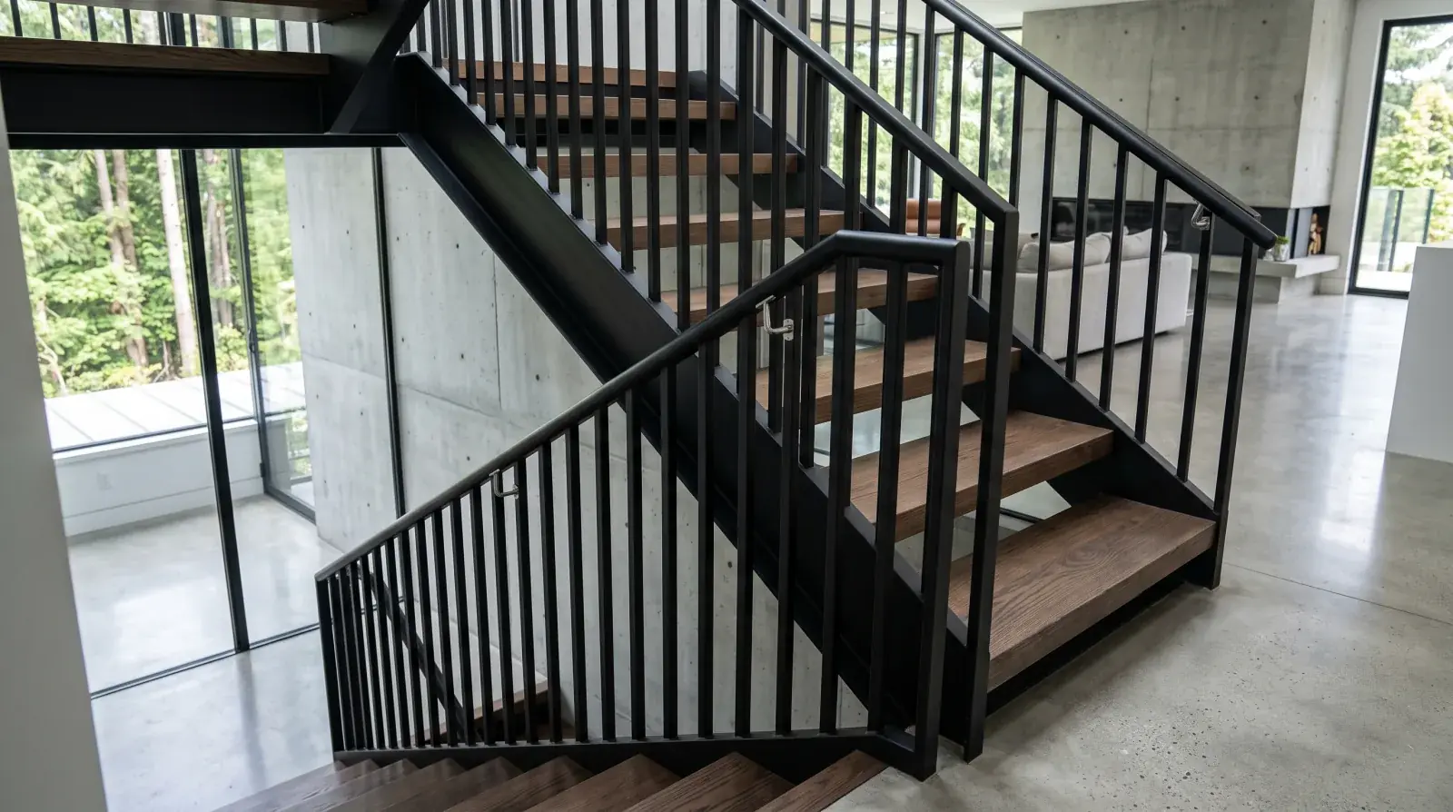 Modern open-tread steel stair in a North Vancouver home with a vertical picket guard and a separate graspable steel handrail