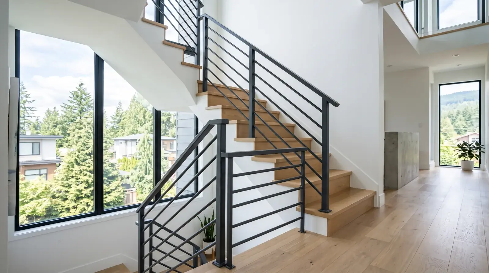 Modern steel stair railing with dark powder-coated posts and horizontal bar infill in a bright Vancouver home