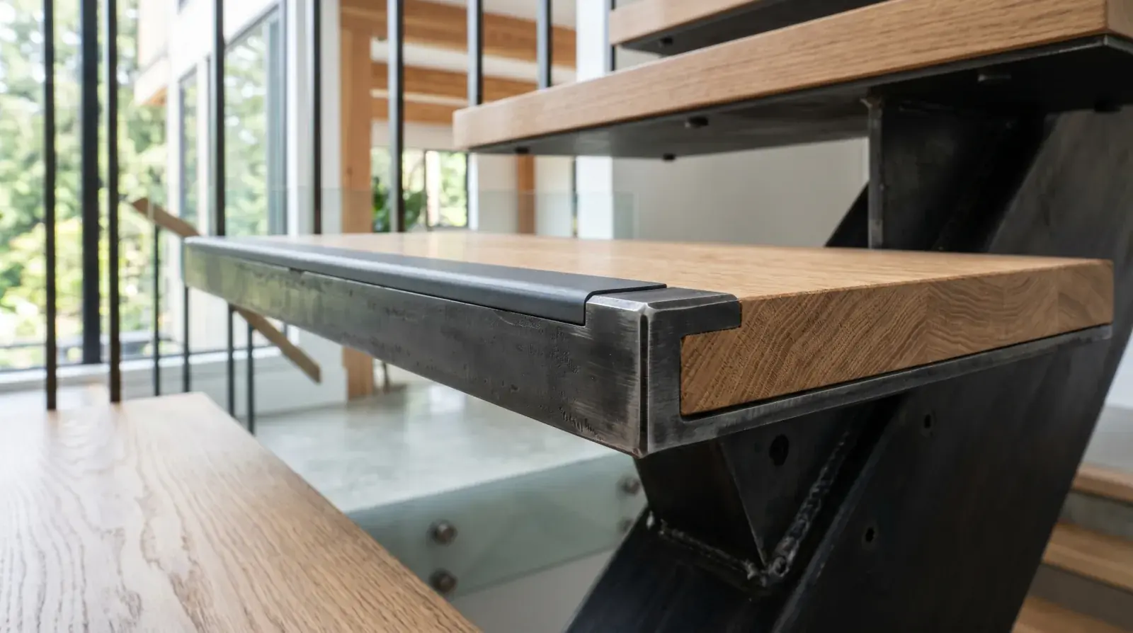Modern blackened steel staircase with anti-slip nosing detail at the leading edge of each tread in a Vancouver home