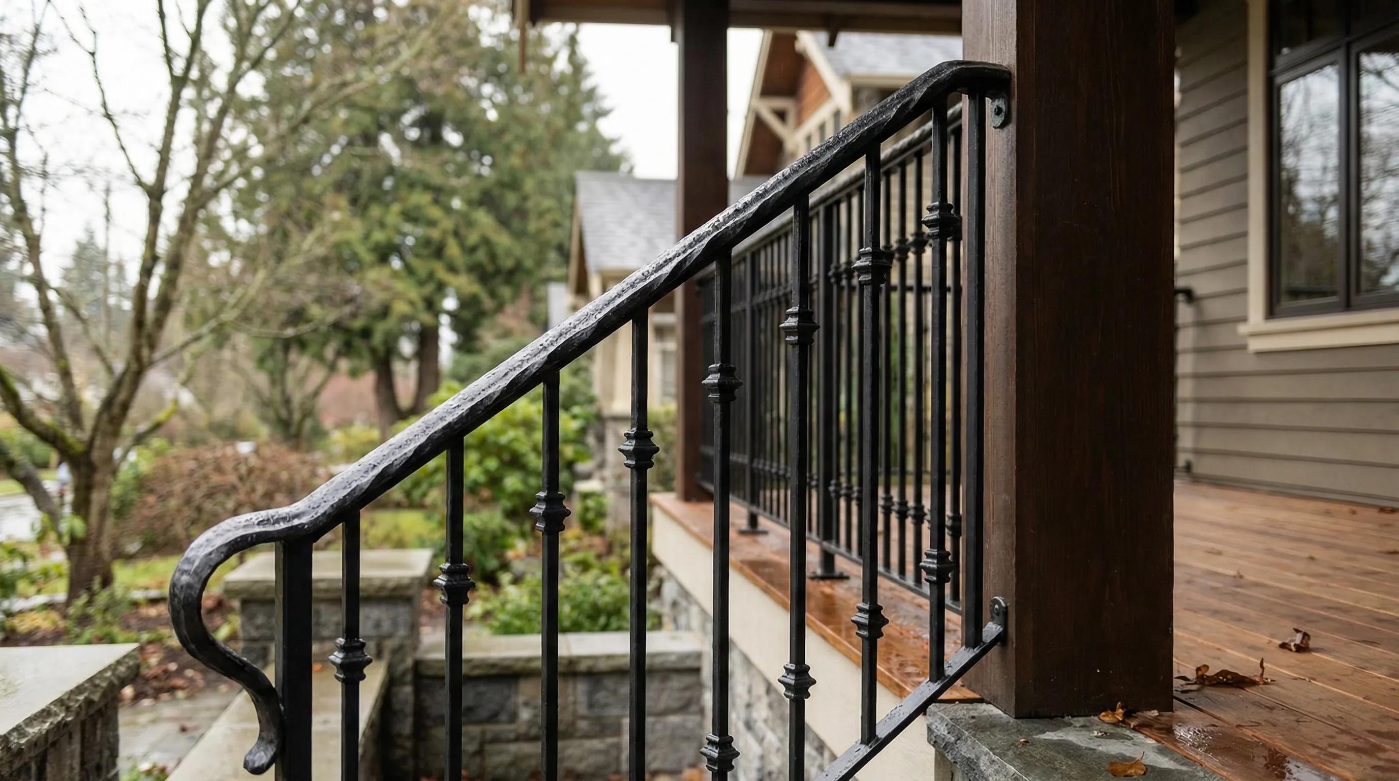 Custom black wrought iron railing with hand-forged top rail on a Vancouver covered front porch