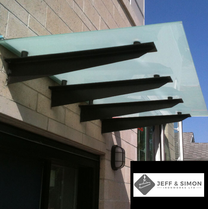 Steel bracket canopy with frosted glass panel over building entrance in Metro Vancouver