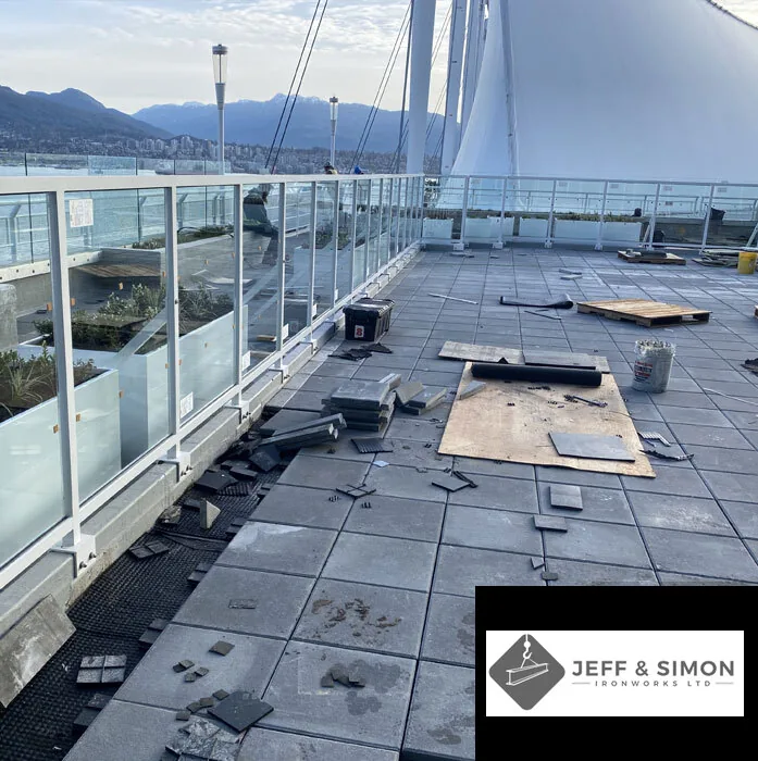 Rooftop glass and metal railing installation with Vancouver harbour and mountains in background