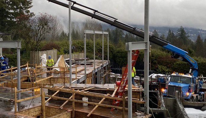Structural steel column and beam erection with crane on residential site in North Vancouver