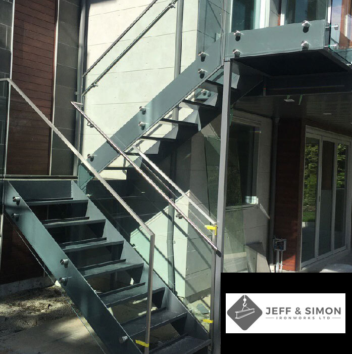 Commercial exterior steel staircase with glass and metal railings on modern building facade