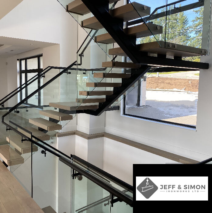 Modern floating staircase with steel mono-stringer, wood treads, and glass railing in Vancouver home