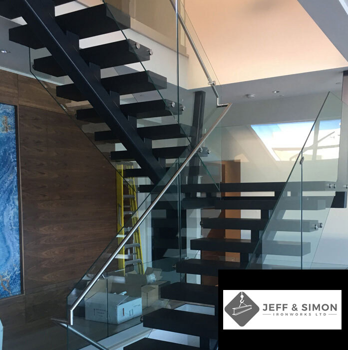 Open-riser steel staircase with glass railing panels in contemporary Vancouver residence